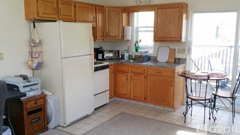 A kitchen with wooden cabinets and white appliances.