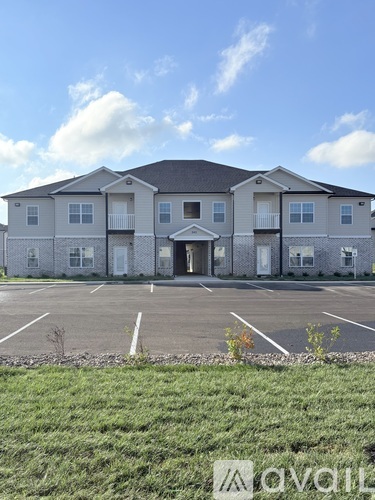 A large two-story building with a parking lot in front.