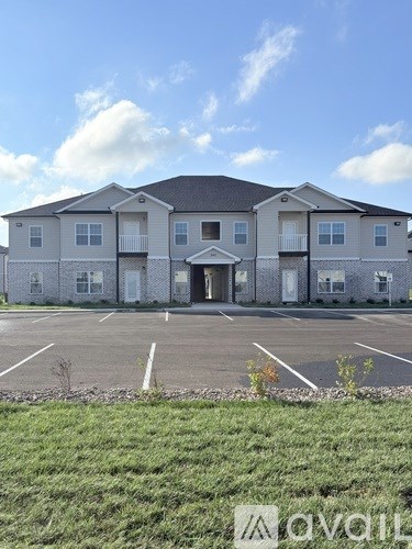 A large two-story building with a parking lot in front.