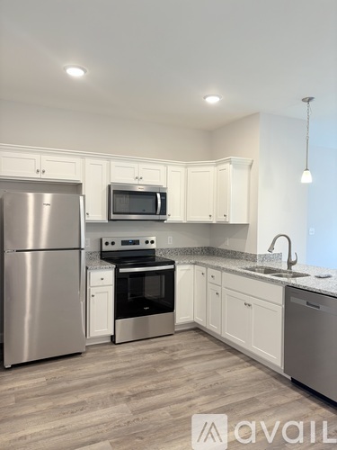 A kitchen with white cabinets and a wooden floor.