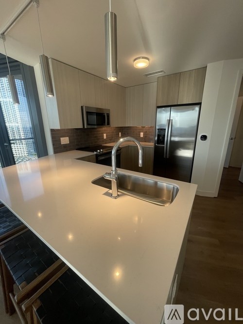 A kitchen with a white countertop and a stainless steel sink.