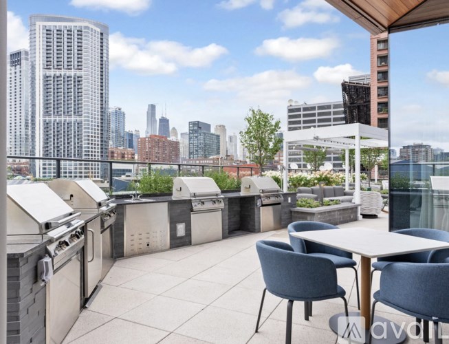 A rooftop patio with a table and chairs overlooking a city skyline.