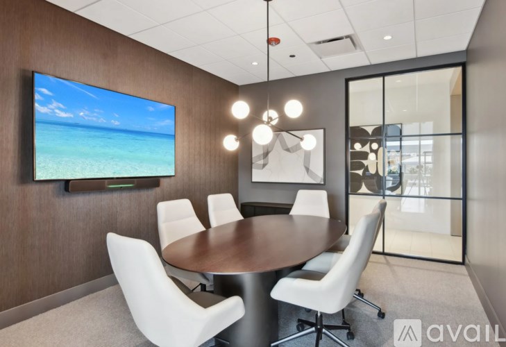 A conference room with a large screen displaying a beach scene.
