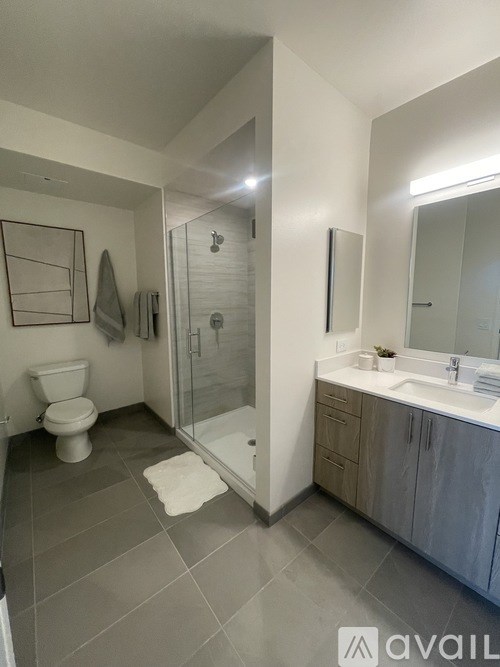 A bathroom with a toilet, sink, and shower.