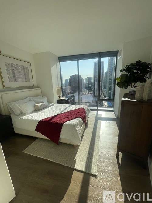A bedroom with a large bed and a view of the city through the window.