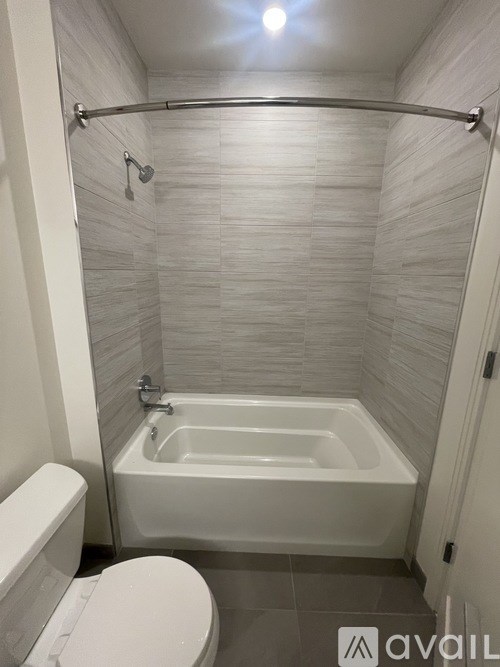 A white toilet sits next to a white bathtub in a bathroom.