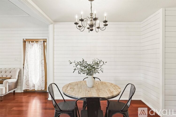 A dining room with a round table and chairs.