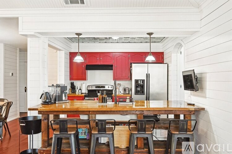A kitchen with red cabinets and a wooden table.