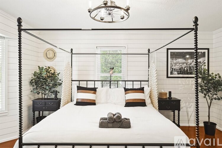 A bedroom with a four-poster bed and a window.
