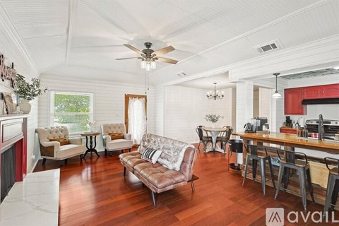 A living room with a brown leather couch and a white ceiling.