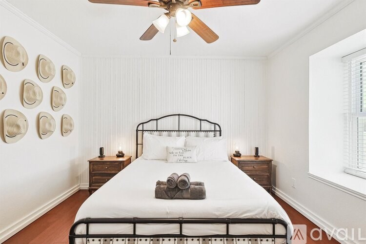 A bedroom with a bed, nightstands, and a ceiling fan.