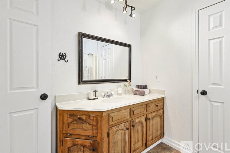 A bathroom with a wooden vanity and a large mirror.