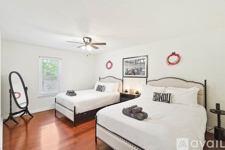 A bedroom with two beds and a mirror.