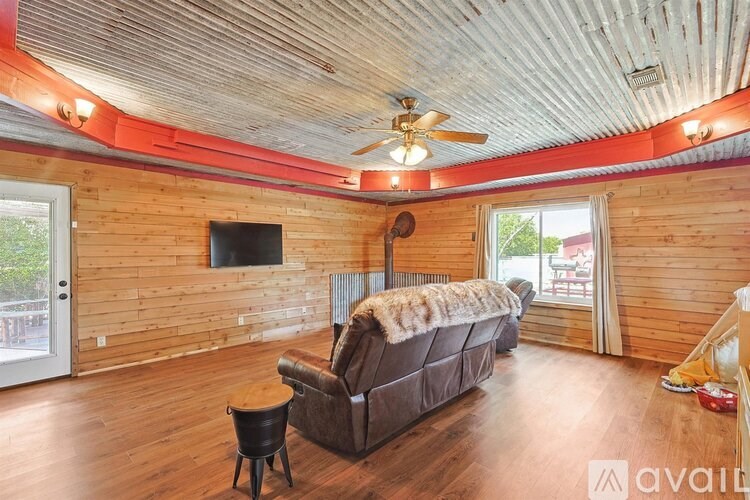 A living room with a brown couch and a ceiling fan.