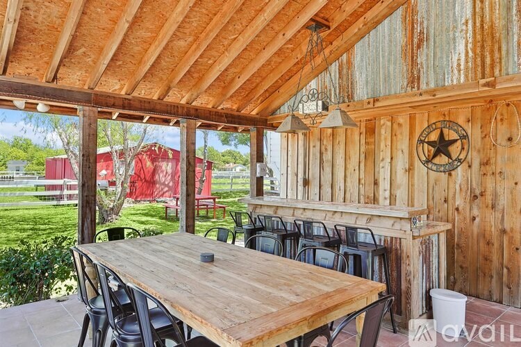 A wooden table is surrounded by chairs in a room with a wooden ceiling.