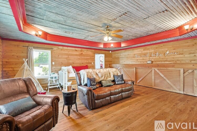 A room with wooden walls and a brown leather couch.