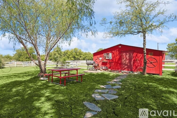 A red building with a picnic table in front of it.