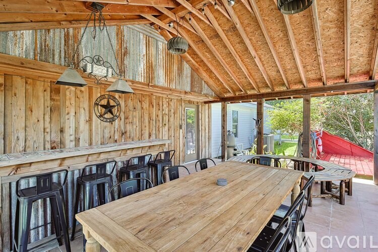 A wooden table is surrounded by chairs in a room with wooden walls.