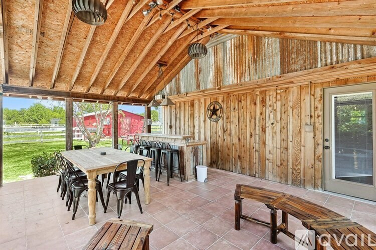 A wooden patio with a table and chairs.
