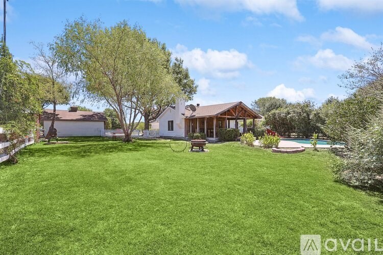 A house with a large lawn and a pool in the backyard.