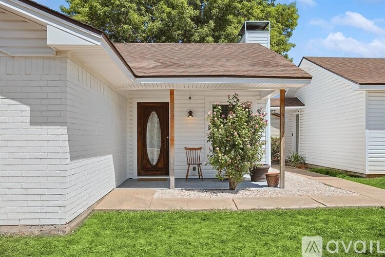 A white house with a brown door and a small porch.