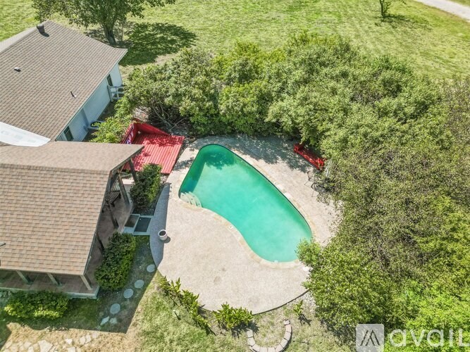 A backyard with a pool and a red slide.