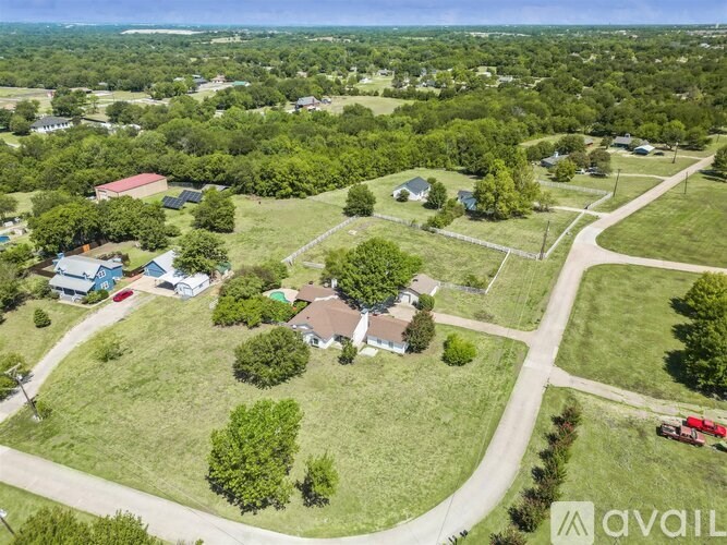 A bird's eye view of a residential area with houses and green lawns.
