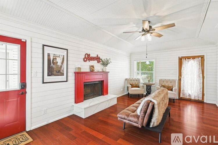 A living room with a red door and a fireplace.