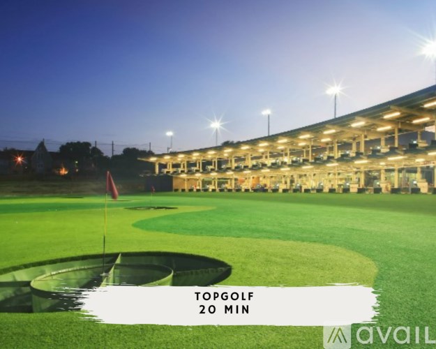 A golf course at night with a sign that says "TOPGOLF 20 MIN".
