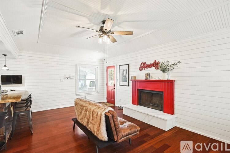 A living room with a red fireplace and a brown leather couch.