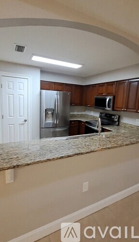 A kitchen with granite countertops and wooden cabinets.