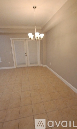A room with tile flooring and a chandelier.