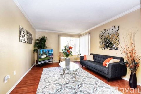 A living room with a black couch and a television.