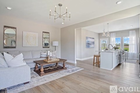 A well-lit living room with a white sofa and a wooden coffee table.