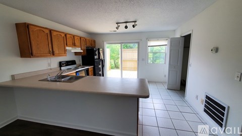 A kitchen with a white counter top and brown cabinets.