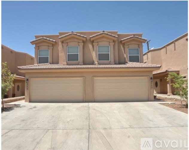 A two-car garage is attached to a tan stucco house.