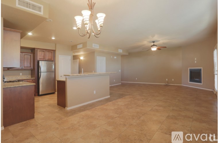 A spacious kitchen with a refrigerator, cabinets, and a countertop.