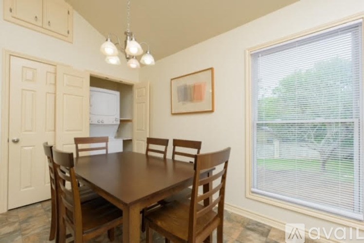 A dining room with a wooden table and chairs.