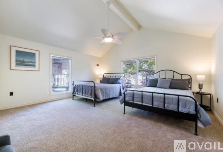 A bedroom with two beds and a ceiling fan.