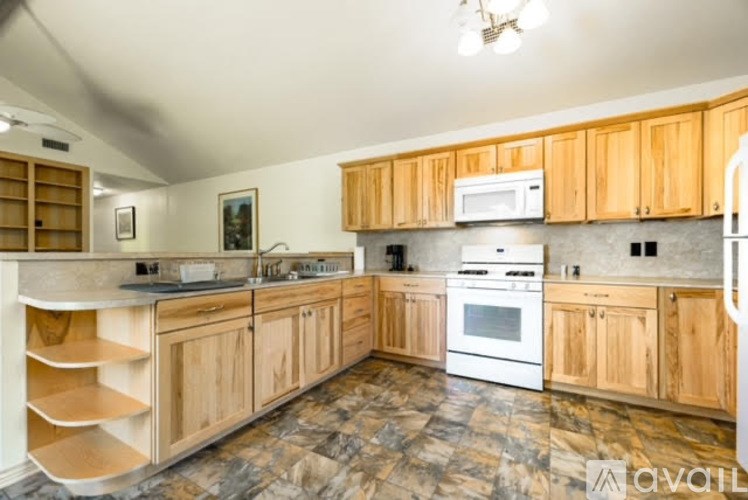 A kitchen with wooden cabinets and a marble floor.