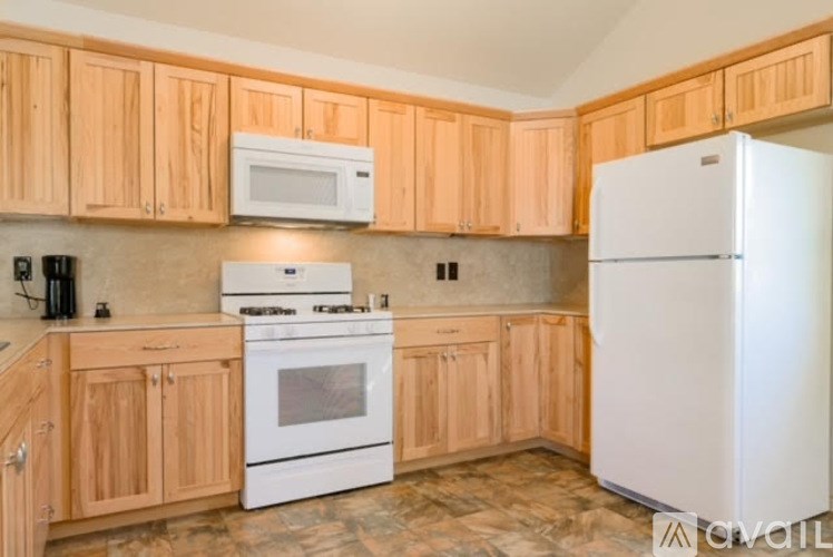 A kitchen with wooden cabinets and a white refrigerator.