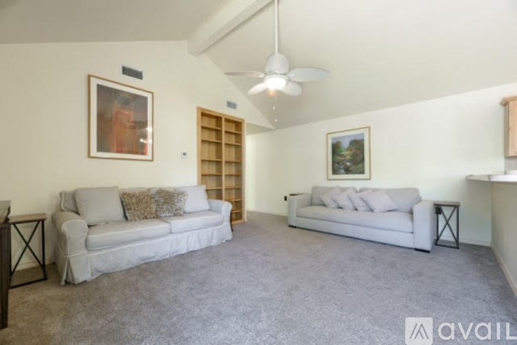 A living room with two couches and a ceiling fan.