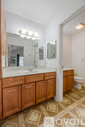 A bathroom with wooden cabinets and a tiled floor.