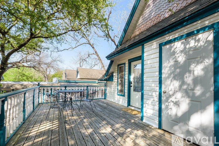 A wooden deck with a table and chairs is surrounded by trees.