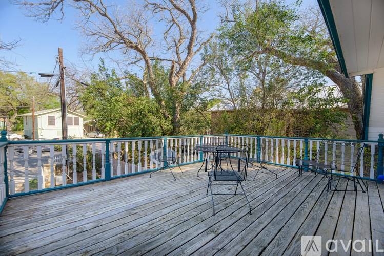 A wooden deck with a table and chairs overlooking a tree.
