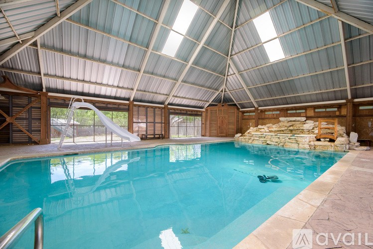 A large indoor swimming pool with a slide.
