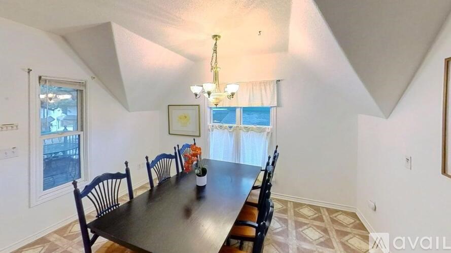 A dining room with a long table and chairs.