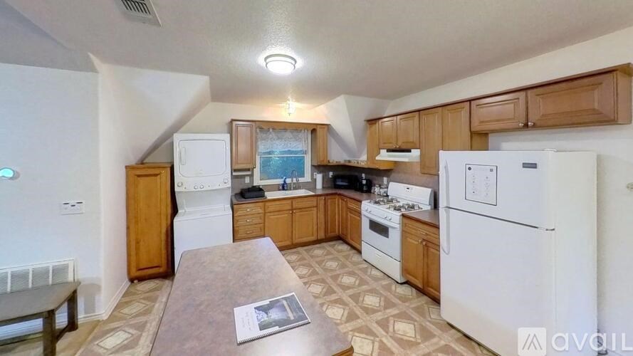 A kitchen with white appliances and wooden cabinets.