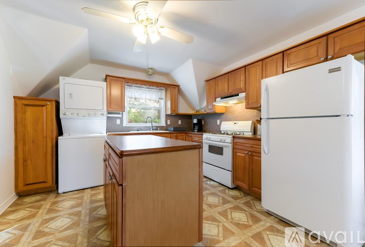 A kitchen with wooden cabinets and a white refrigerator.
