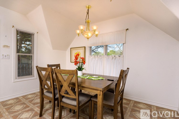 A dining room with a wooden table and chairs.